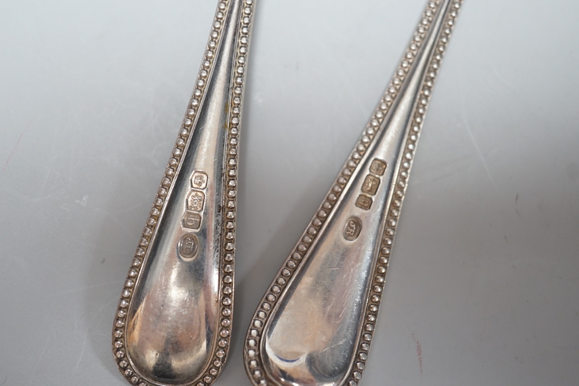 A set of twelve early 20th century silver beaded old English pattern dessert spoons Sheffield, 1908 & 1910 and twelve matching dessert forks, Sheffield, 1919, all by John Round & Sons, oak cased, 46.7oz